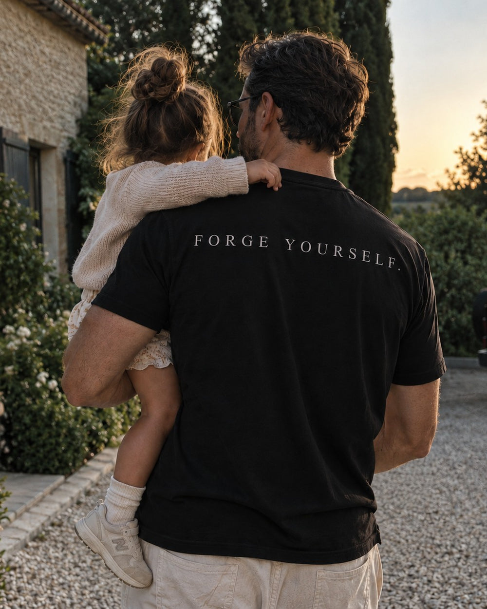 A father carrying his daughter, FORGE YOURSELF on his tee